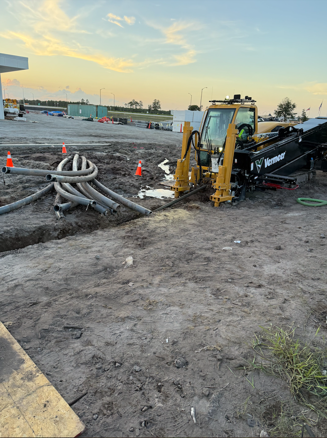 A yellow truck is drilling a hole in the ground.