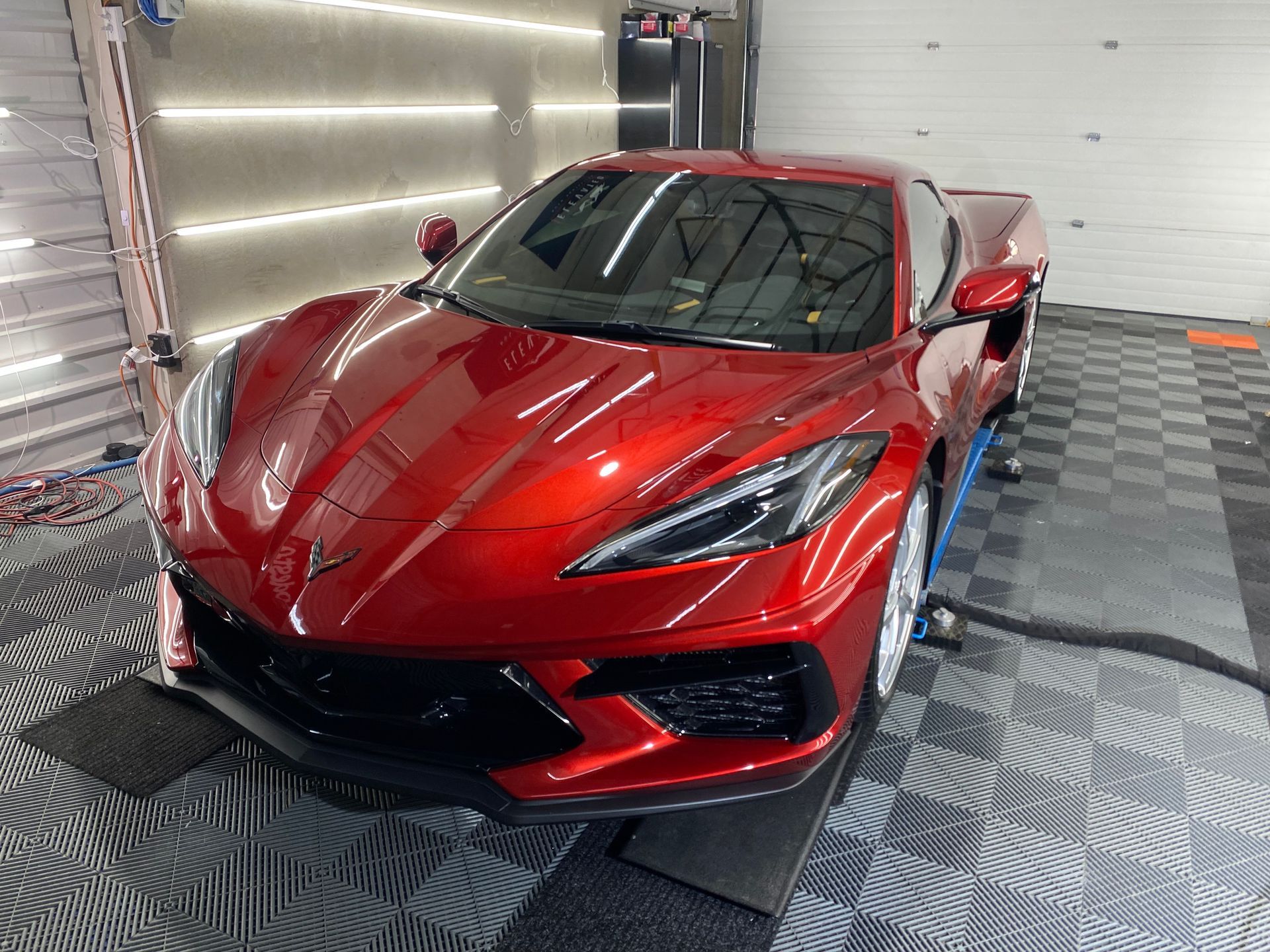 A red sports car is parked in a garage.