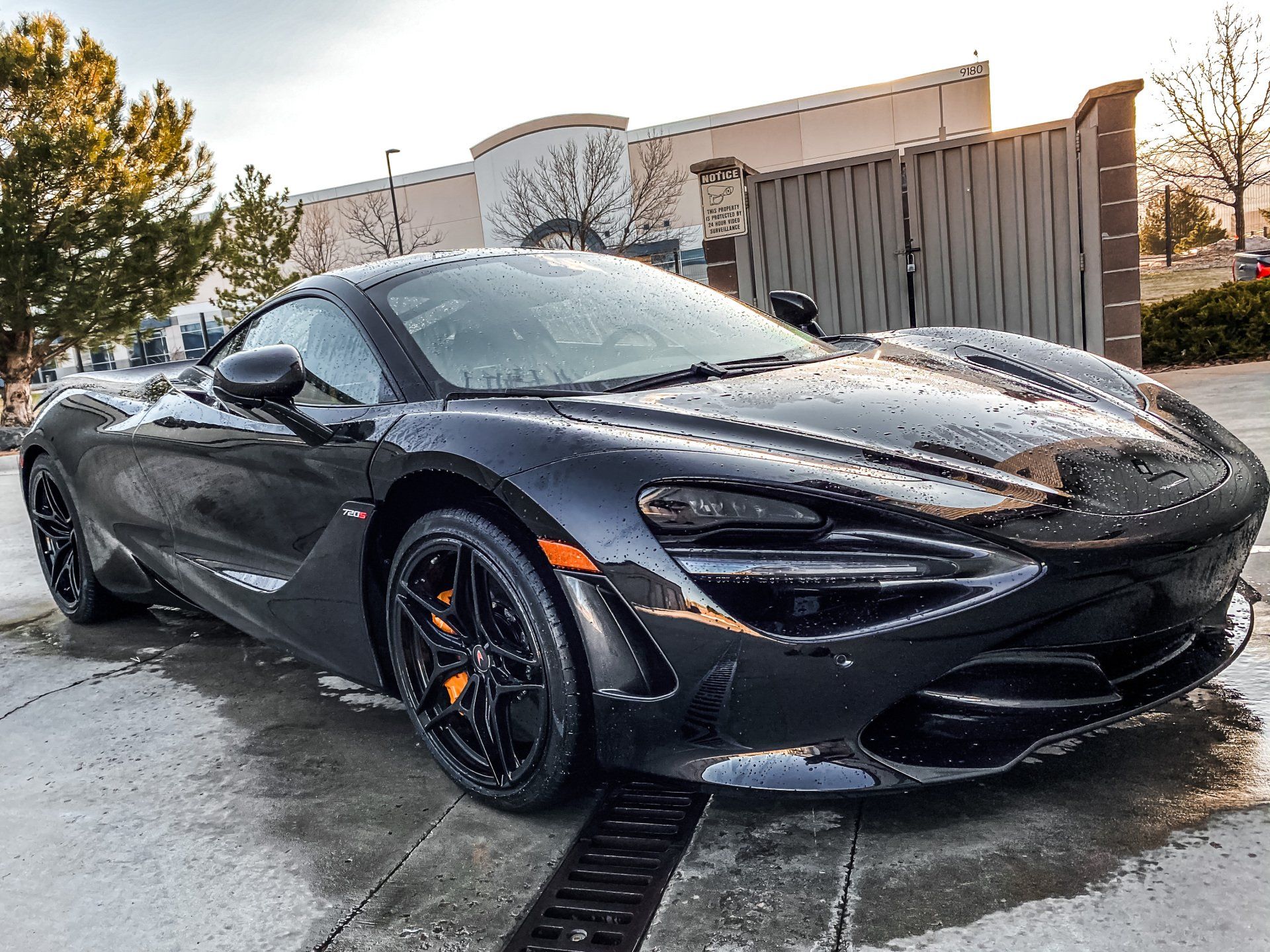 A black sports car is parked in front of a building.