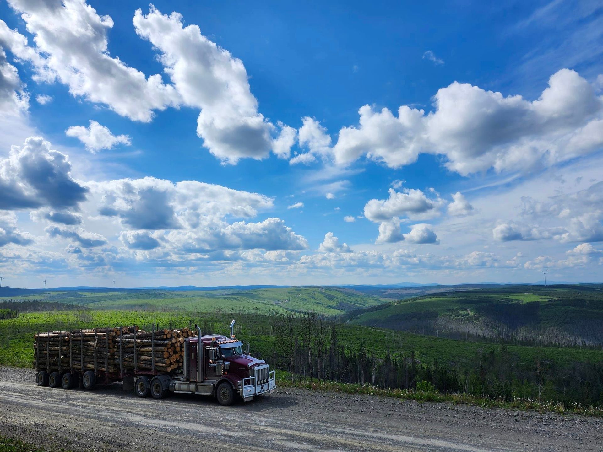 Un semi-camion roule sur un chemin de terre dans les montagnes.
