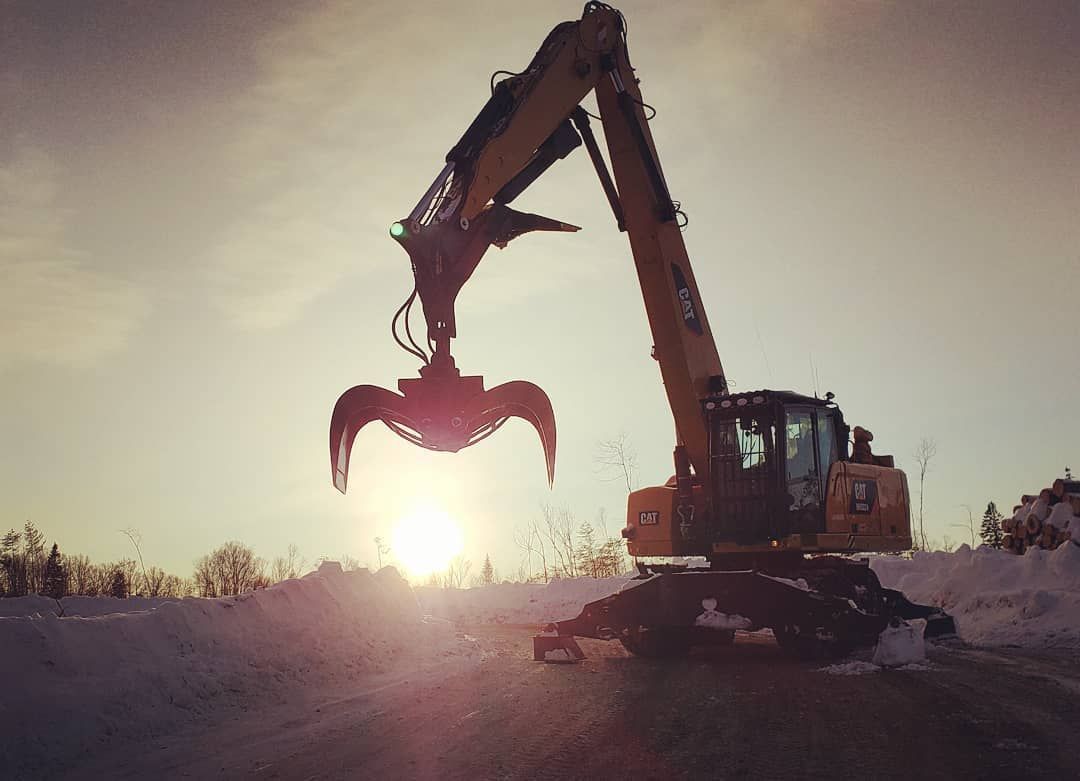 Une grande excavatrice jaune avec une grande griffe dessus