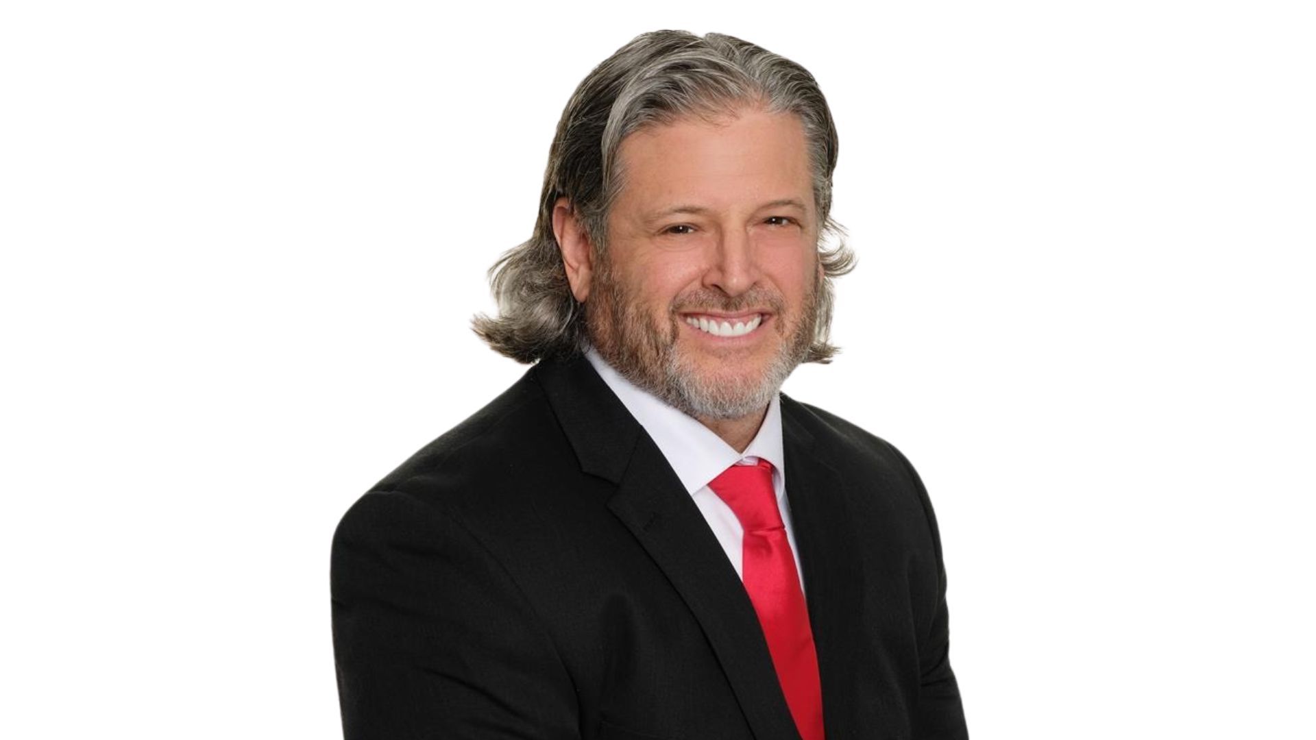 A man in a suit and red tie is smiling for the camera.