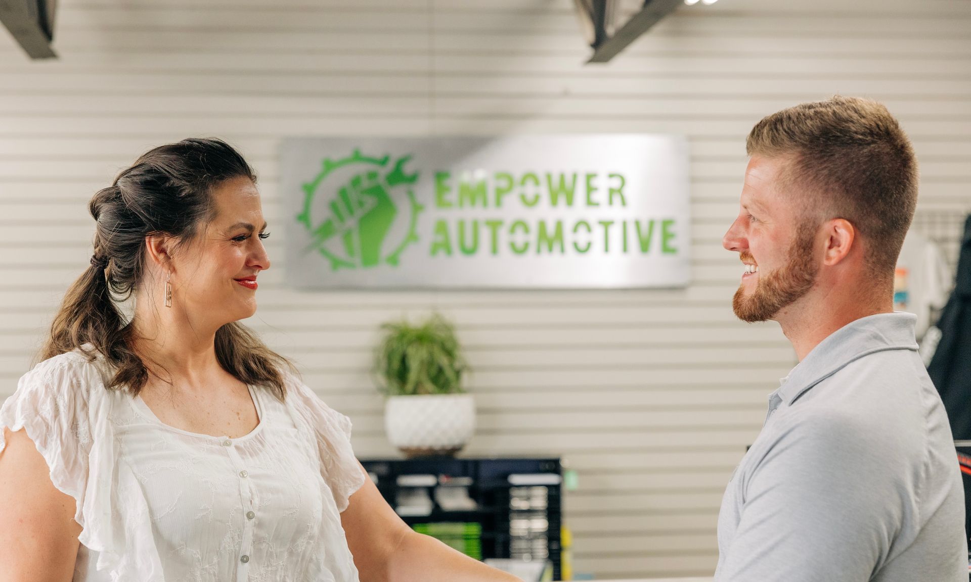 Woman and man smiling and talking in front of an 