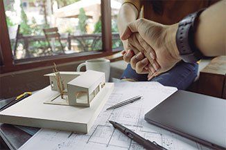 Roofing Contractor — An architect and businessman shaking hands with miniature house in Red Bank, NJ