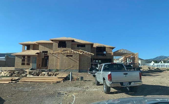 A truck is parked in front of a house under construction