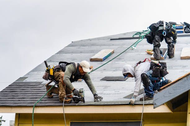 A group of construction workers are working on a roof.