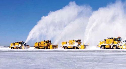 A Row of Yellow Snow Plows Blowing Snow in a Snowy Field — Portsmouth, NH — Lager Susan R