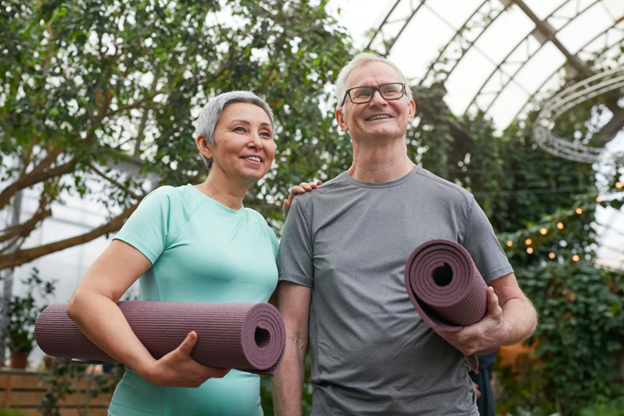 A Man and a Woman Are Standing Next to Each Other Holding Yoga Mats — Portsmouth, NH — Lager Susan R