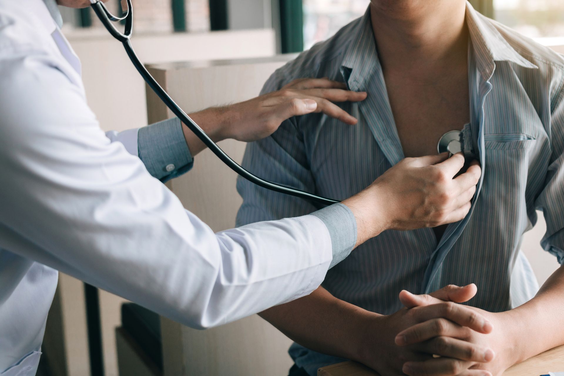 Doctor at Davenshire Medical Center, a primary care center in York, PA, listening to patient’s heartbeat with a stethoscope