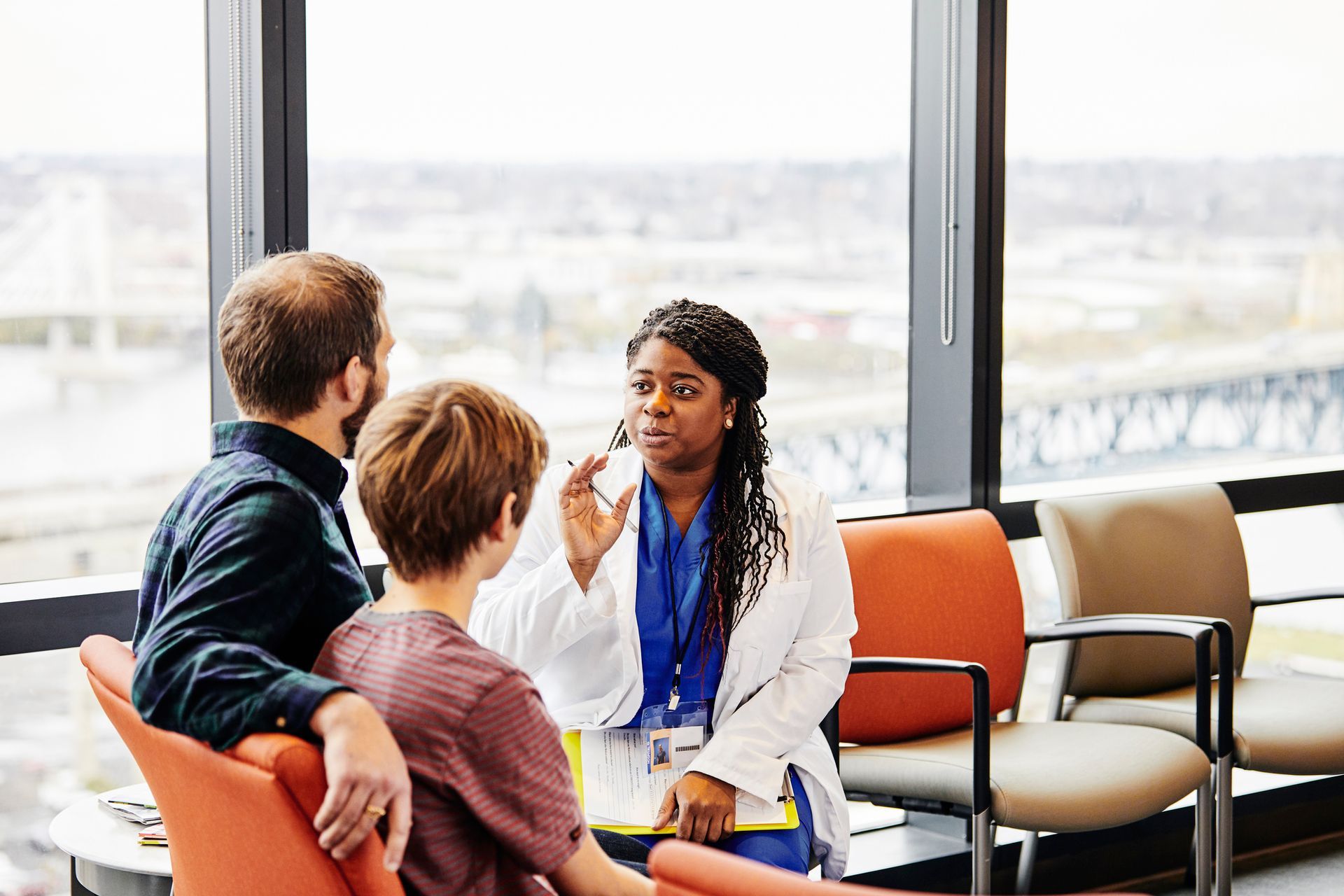 A doctor is talking to a patient in a hospital waiting room.