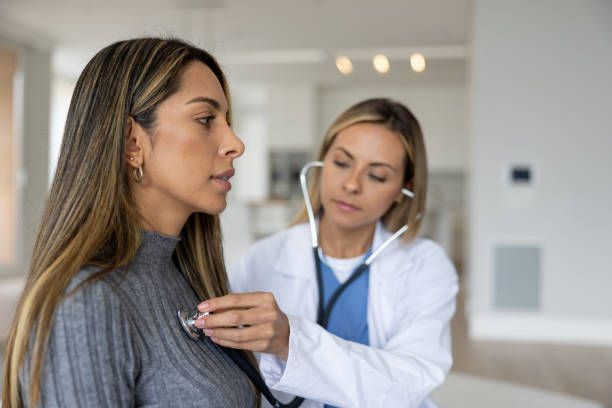 Female doctor examining patient at primary care center, healthcare consultation, medical check-up,