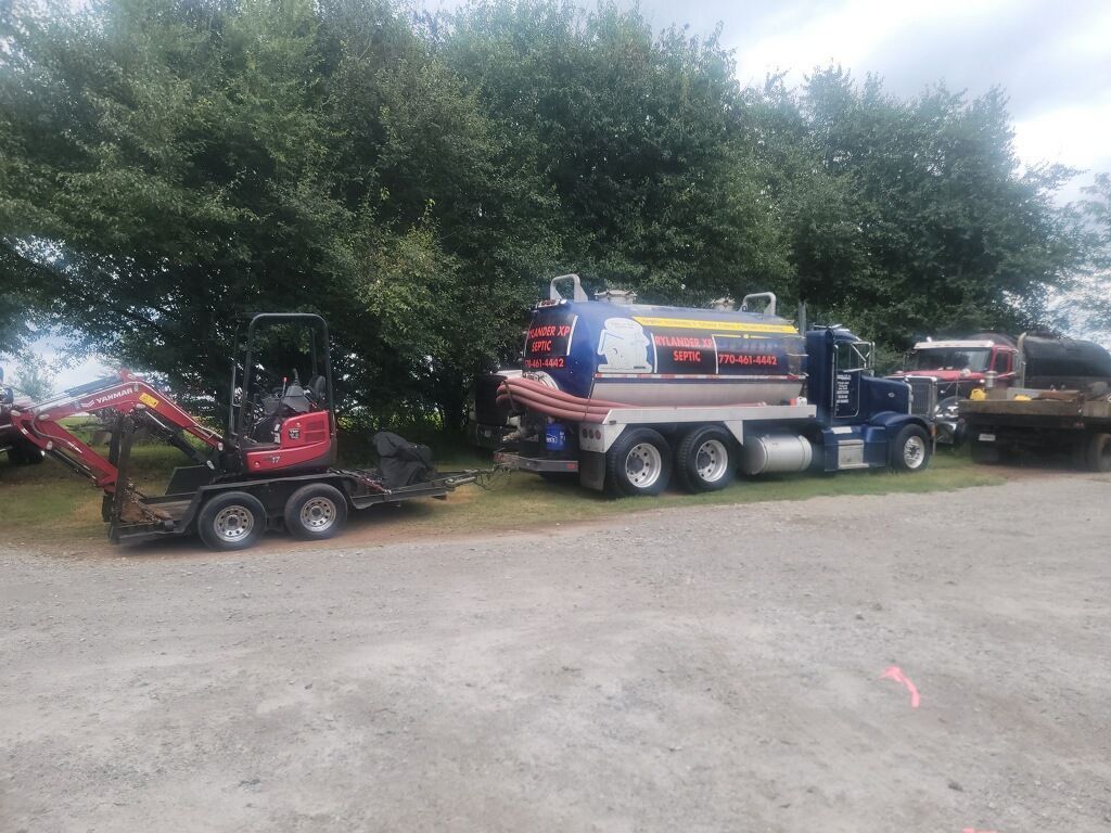 Blue Septic Truck & Red Excavator On Gravel