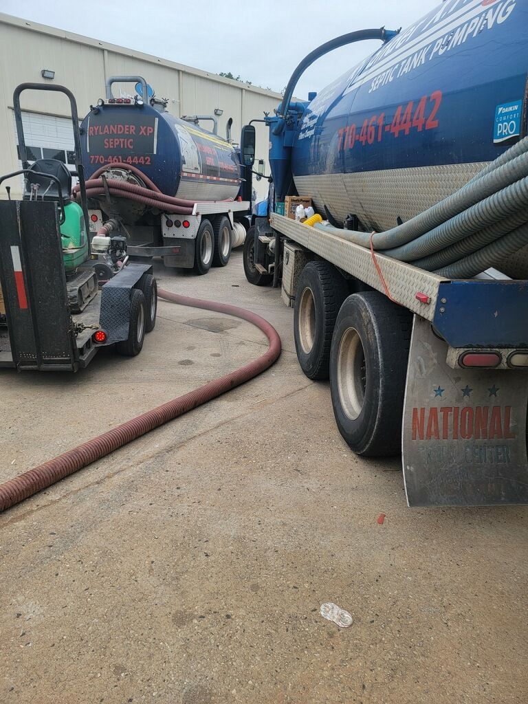 Two Blue Tanker Trucks With Hoses Parked