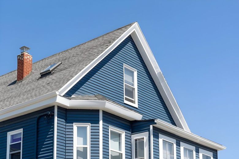 A blue house with a gray roof and white trim