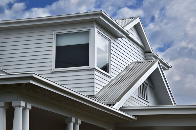 A blue house with a gray roof and white trim