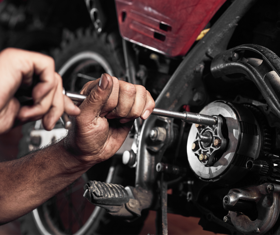 A man is working on a motorcycle with a wrench