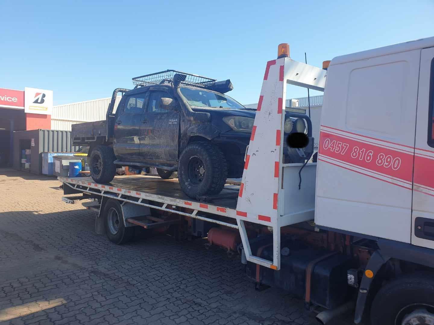 A truck is being towed by a tow truck.