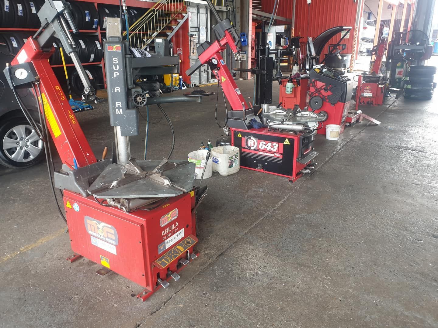 A row of tire changers are lined up in a garage