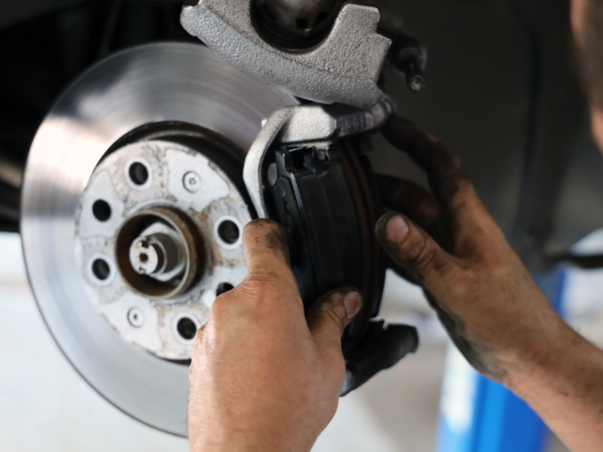 A person is fixing a brake disc on a car.
