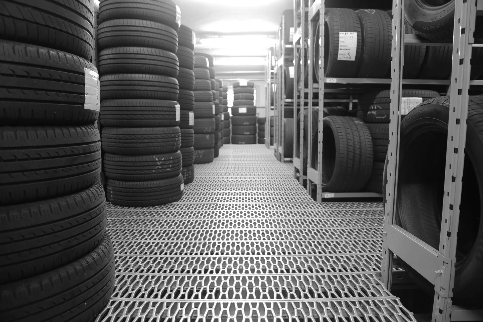 A black and white photo of a warehouse filled with lots of tires