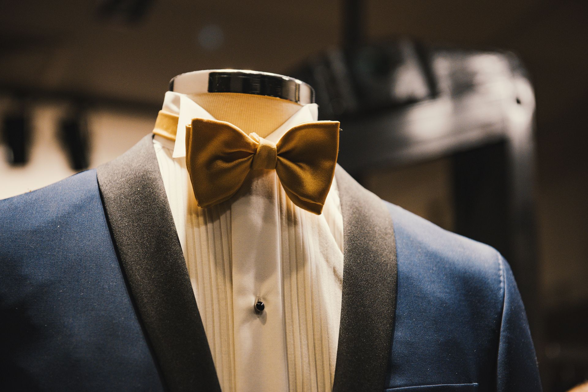 a blue suit with a yellow bow tie on a mannequin