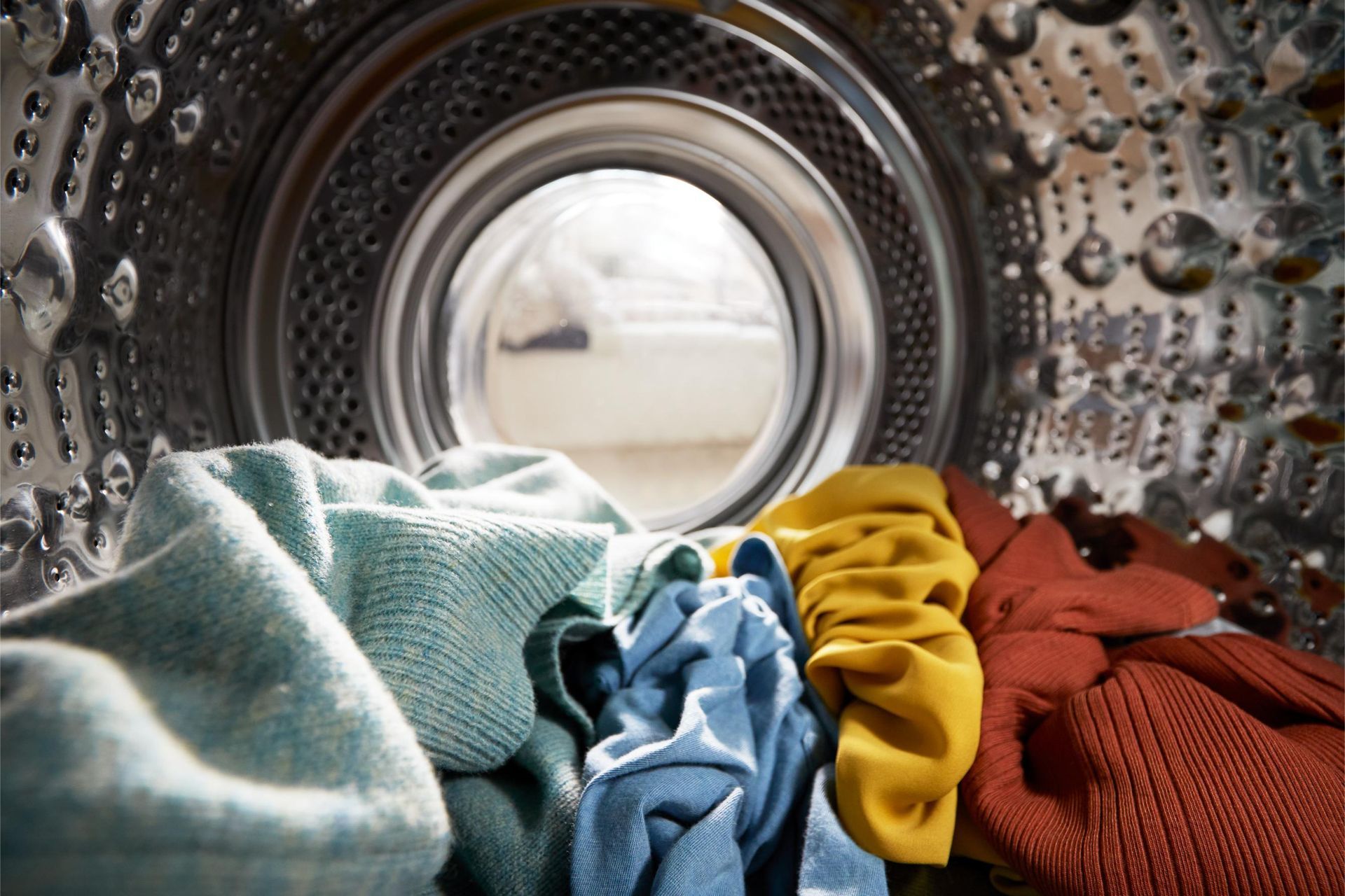 a close up of a washing machine filled with clothes