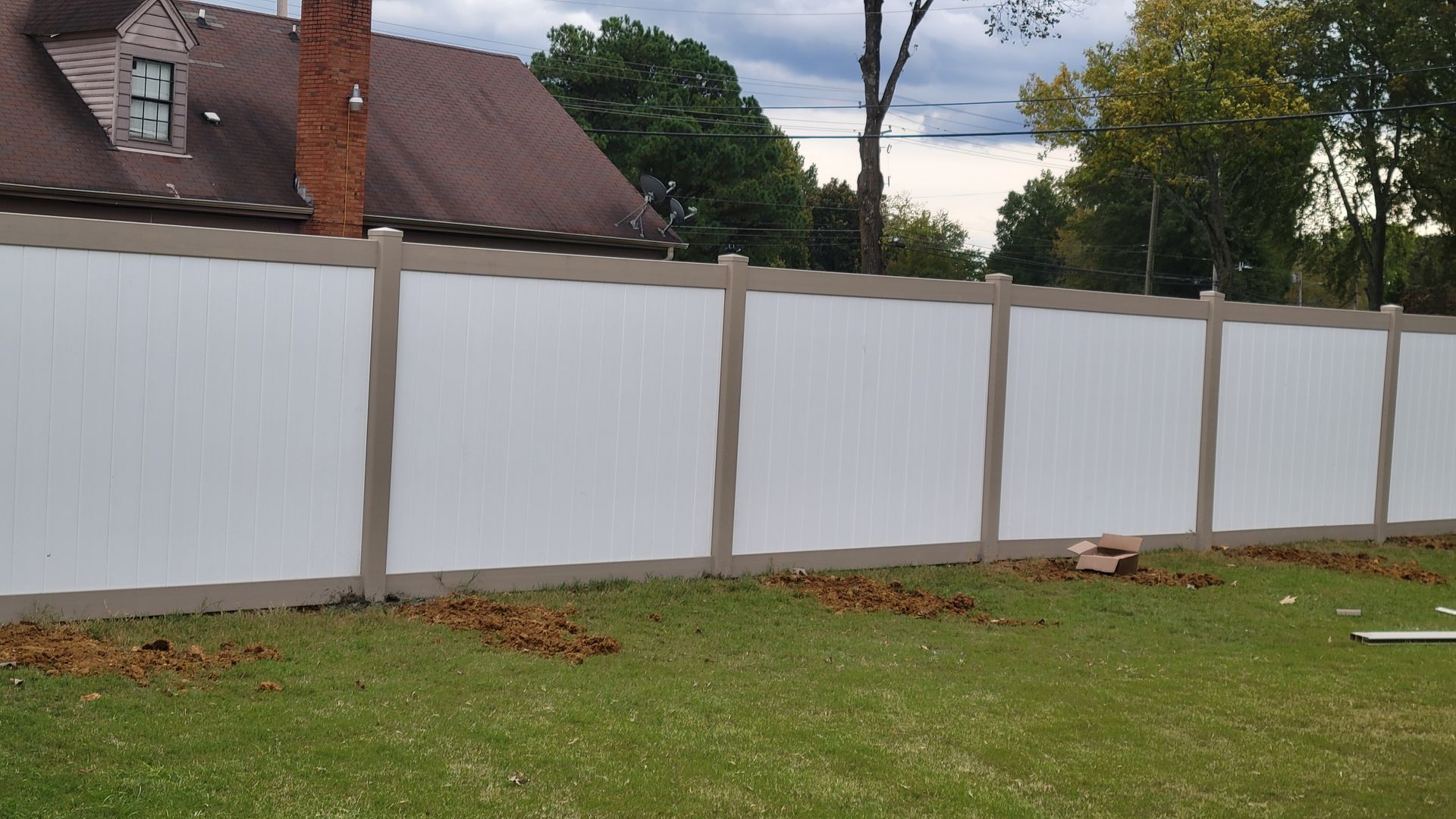 White picket fence bordering a green lawn.