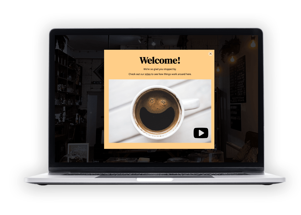 A laptop computer is open to a welcome page with a cup of coffee on the screen.