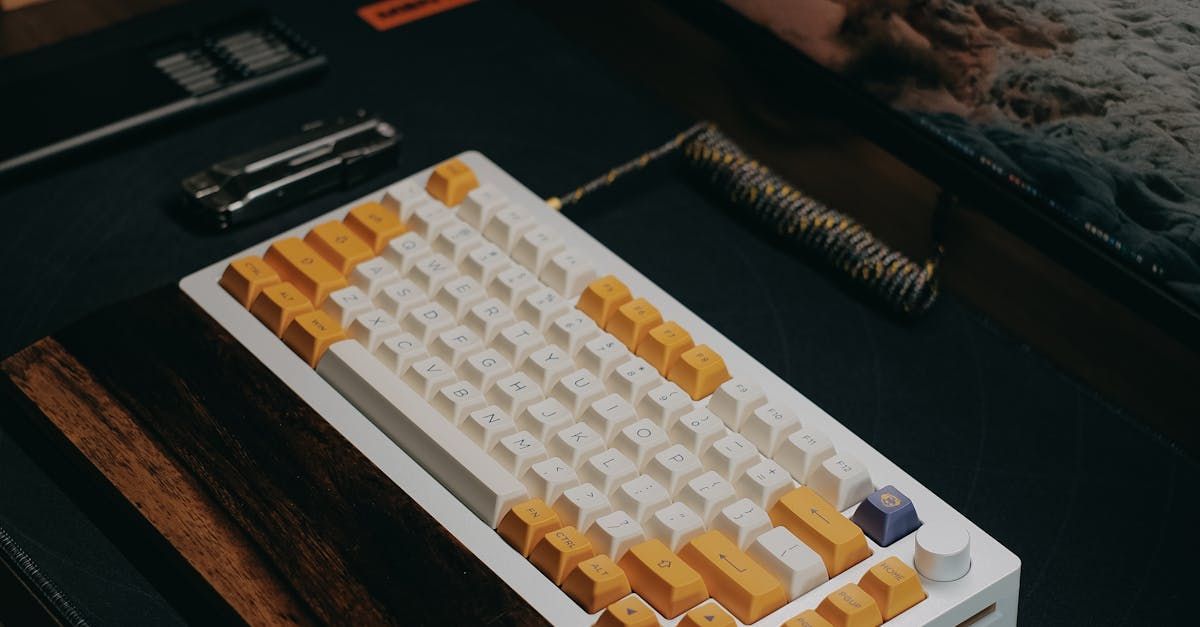 A white and yellow keyboard is sitting on top of a wooden table.