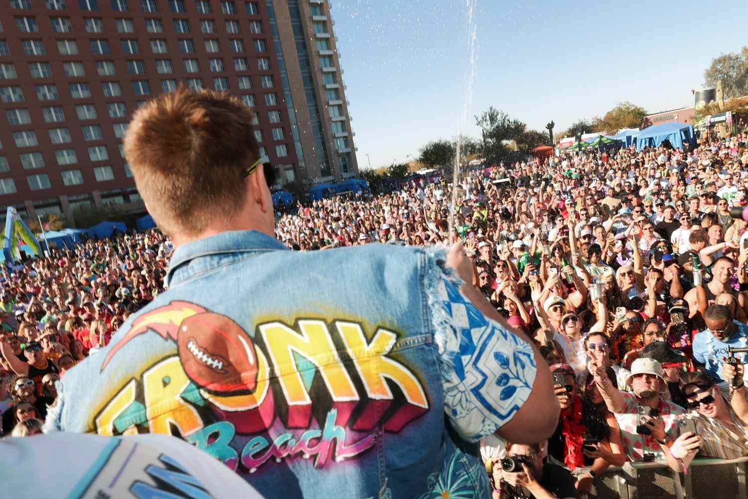 A man is standing in front of a crowd wearing a shirt that says ronk