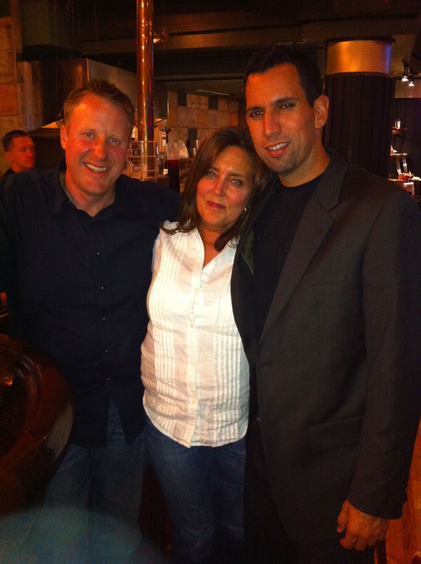 A man in a suit and a woman in a white shirt are posing for a picture