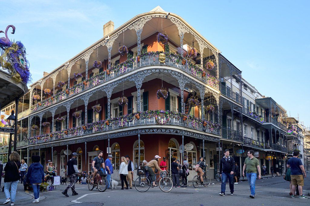 A group of people are walking in front of a large building.