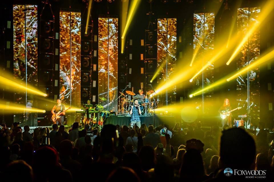 A band is playing on a stage in front of a crowd.