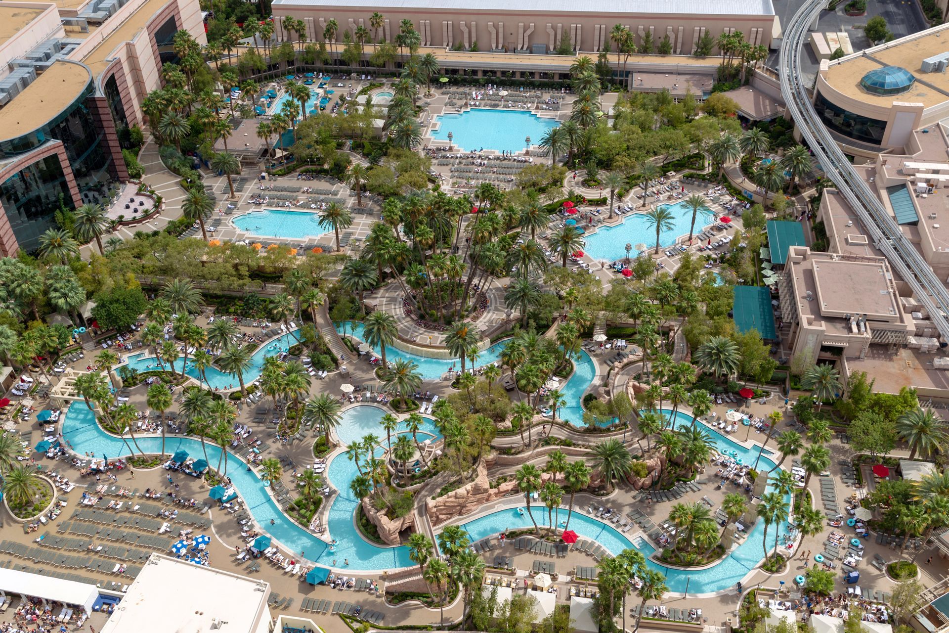 An aerial view of a water park with lots of swimming pools and a water slide.