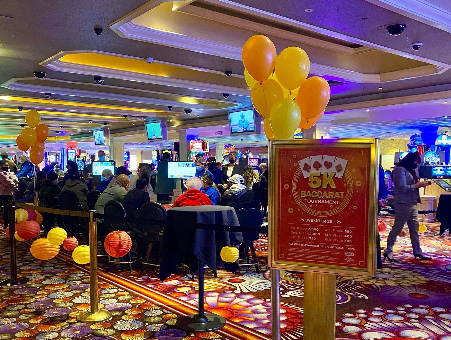 A group of people are sitting at tables in a casino.