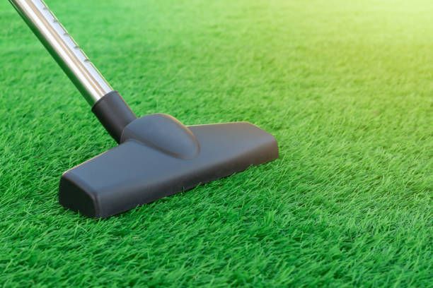 A vacuum cleaner on a sheet of artificial turf.