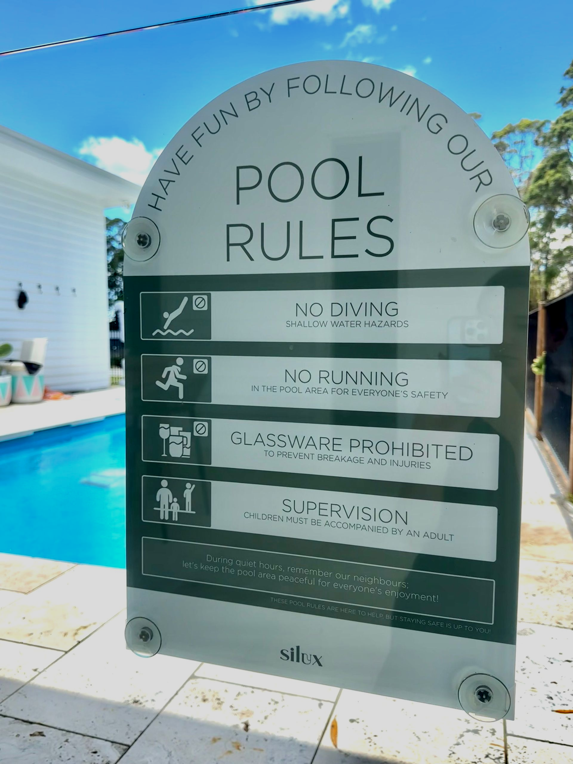 Pool rules sign near a pool: no diving, no running, supervised children, no glass.