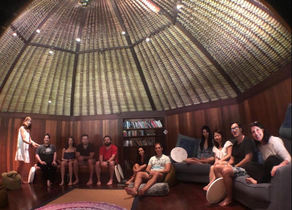 A group of people are sitting in a room under a dome.