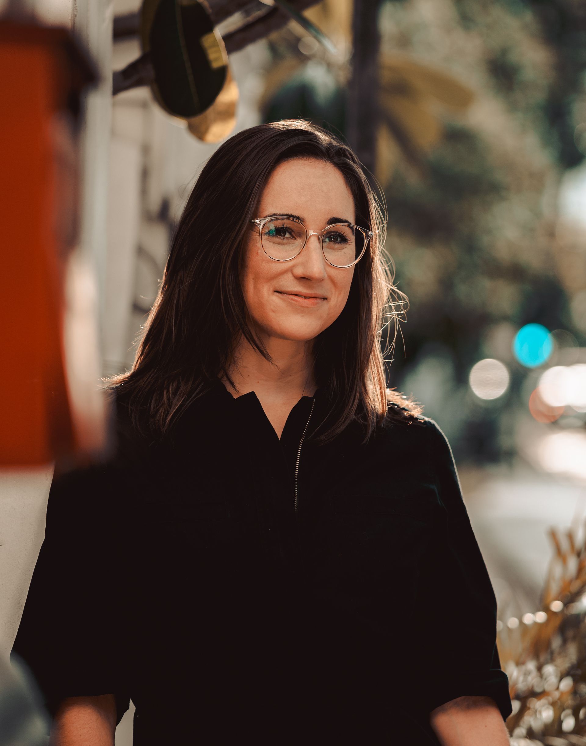 A woman wearing glasses and a black shirt is smiling for the camera.