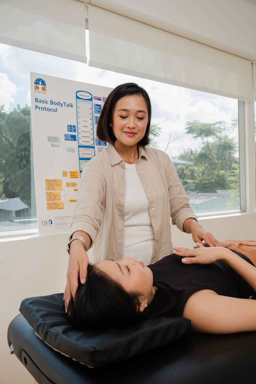 A woman is giving a massage to a woman laying on a table.