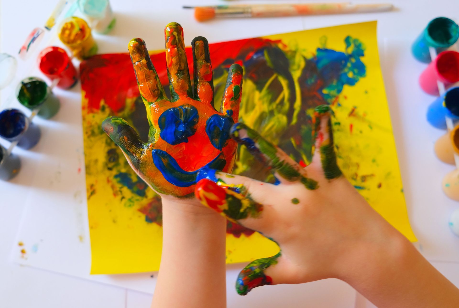 A child is painting a picture with their hands.