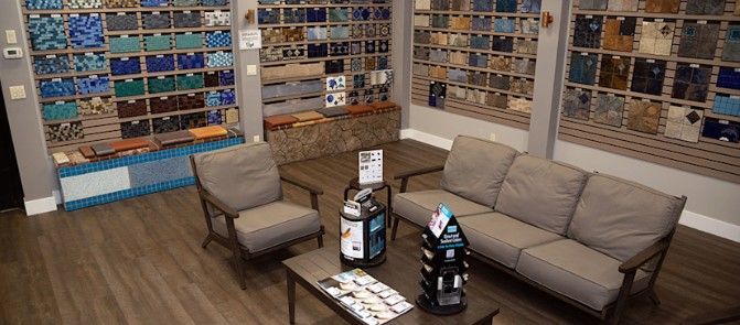 Modern lounge with gray sofas, an armchair, coffee table, and wall-to-wall shelves in a cozy retail space