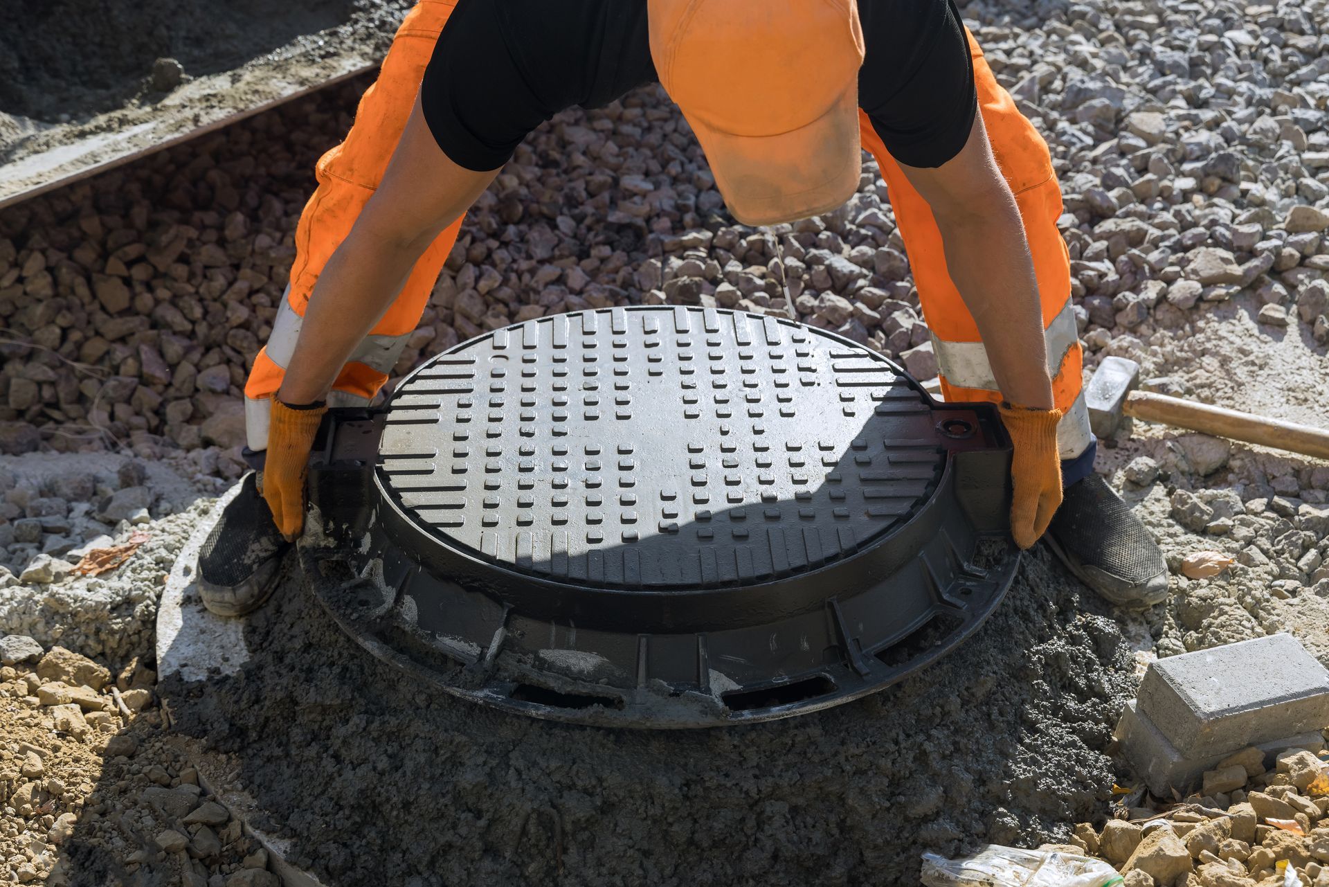 Technician installing septic tank lid during septic system repair on residential property site. Technician installing septic tank lid during septic system repair on residential property site.