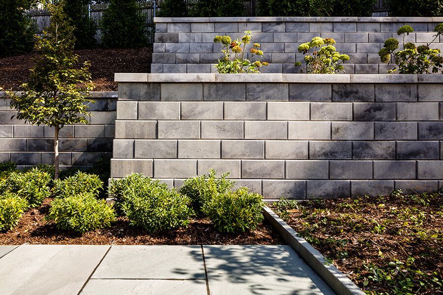 A brick wall surrounds a lush green garden