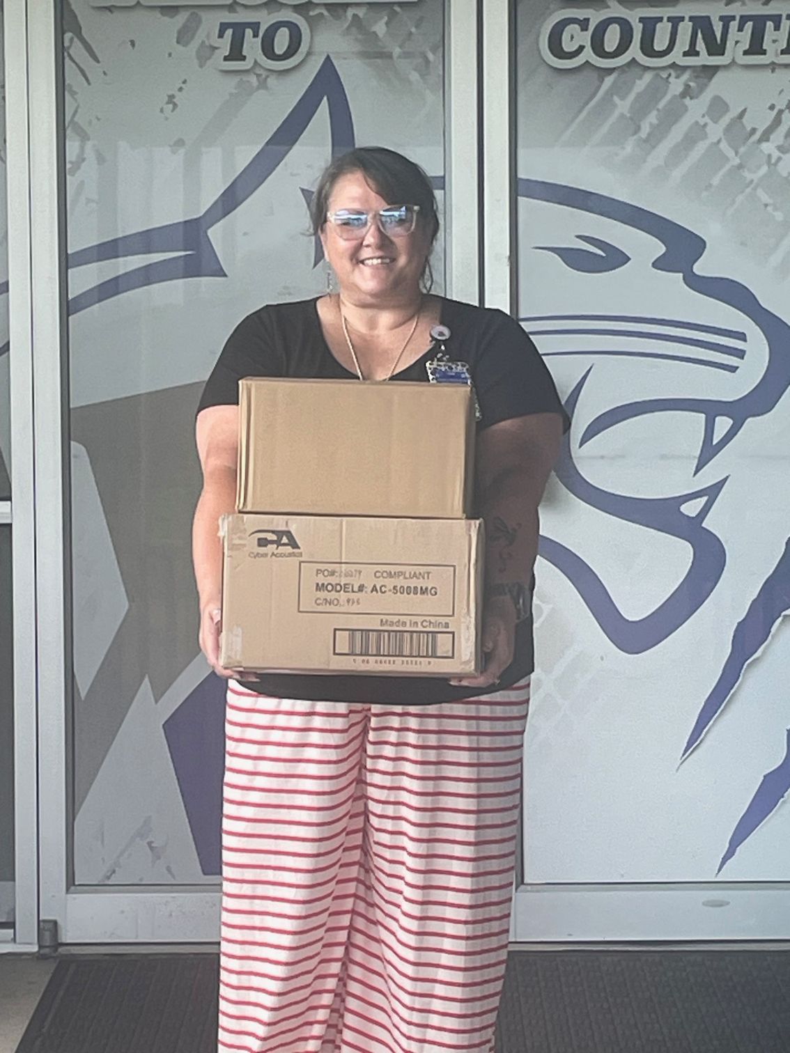 A woman is holding two boxes in front of a sign that says count