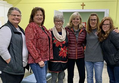 A group of women are posing for a picture together in a room.