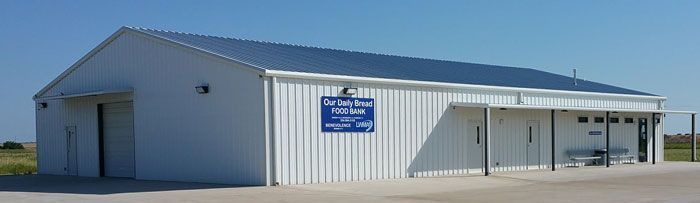 A large white building with a blue sign on the side of it.