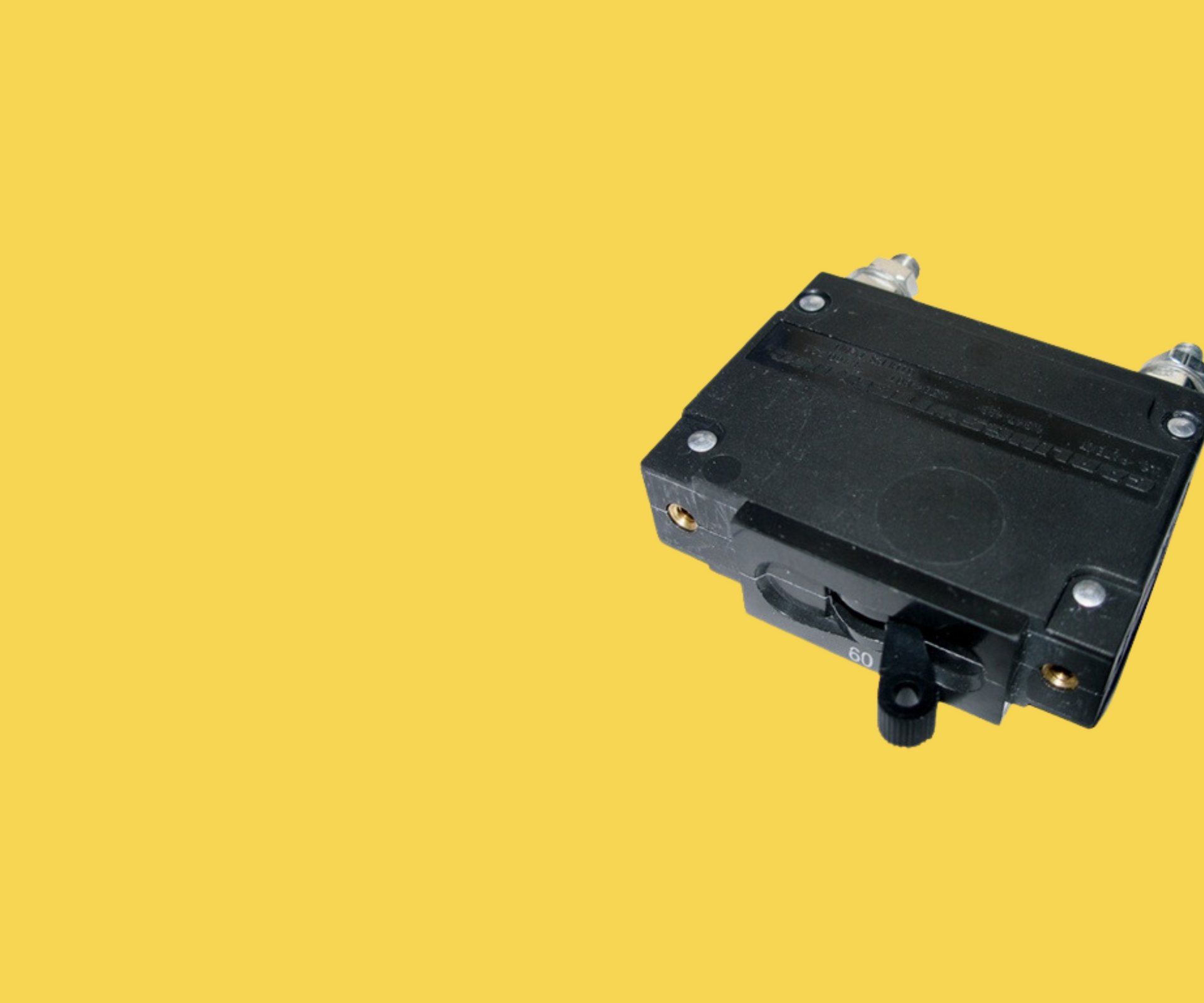 A black electrical device is sitting on a yellow surface.