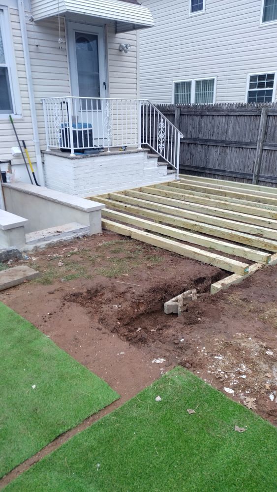 A wooden deck is being built in the backyard of a house