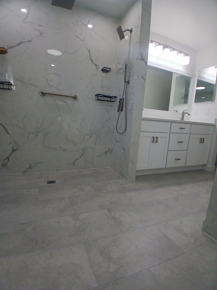 A bathroom with a walk in shower, sink and mirror